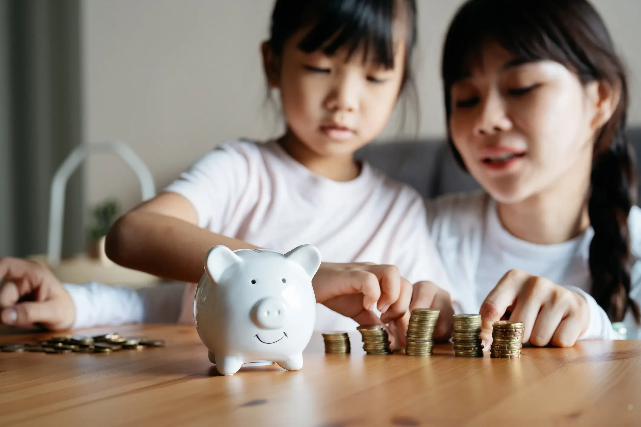 Adult and child learning about savings with a piggy bank and coins