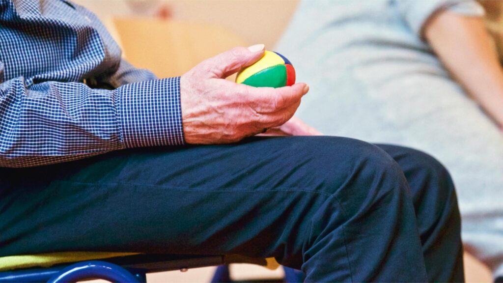 Senior sitting on bench with puzzle ball