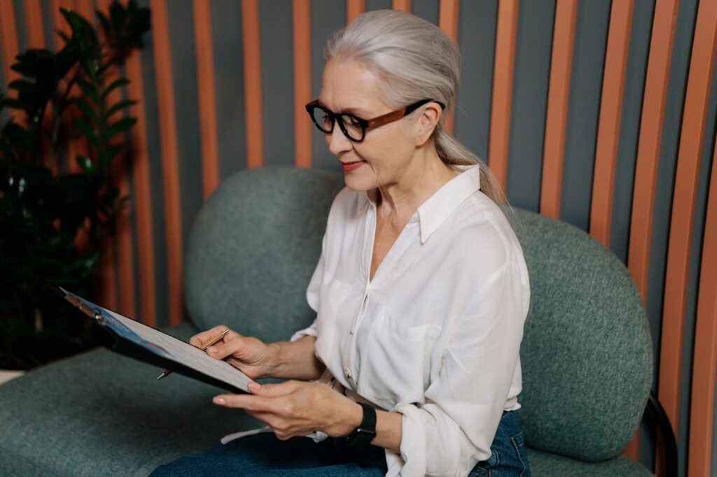 Woman looking at paperwork on a clipboard smiling