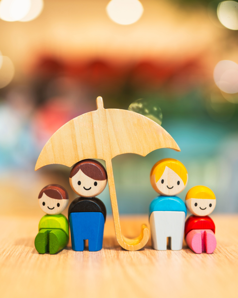 Small wooden figurines; family underneath umbrella